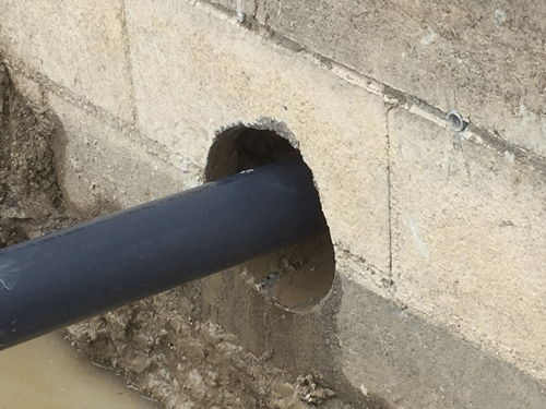 Horizontal sub-slab vapor extraction well installed through building footing 